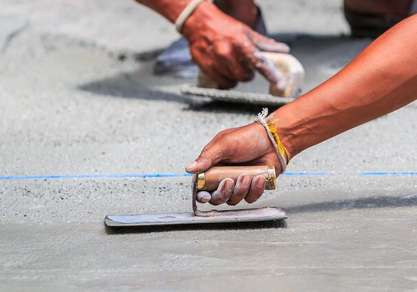 A tradesperson using a towel to smooth the surface.