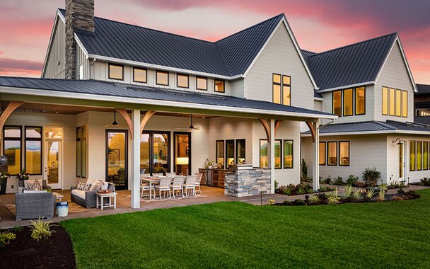A beautiful home exterior with an outdoor patio at twilight. 