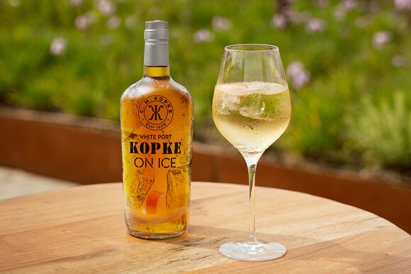 Bottle of Kopke White Port On Ice alongside a chilled glass of white port served over ice