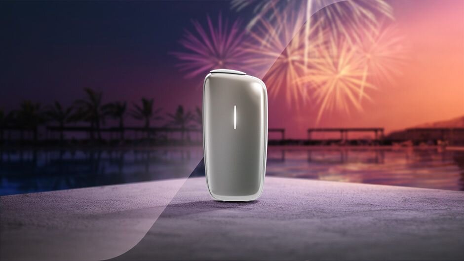 Ploom X Advanced Silver a letní podvečerní obraz s ohňostrojem.