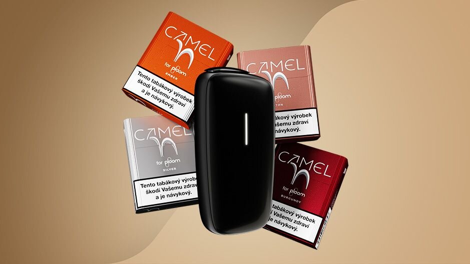 Černé zařízení Ploom X a 4 krabičky Camel náplní - Amber, Tan, Silver, Burgundy - na béžovém pozadí.