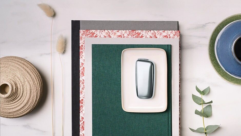 Stříbrné zařízení Ploom X na barevných sešitech