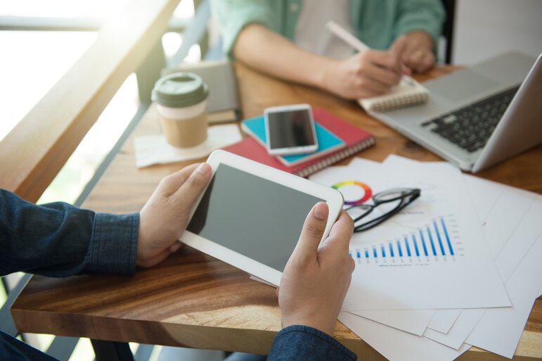 Business Team Briefing zur Marketingstrategie mit Smartphone und Tablet.