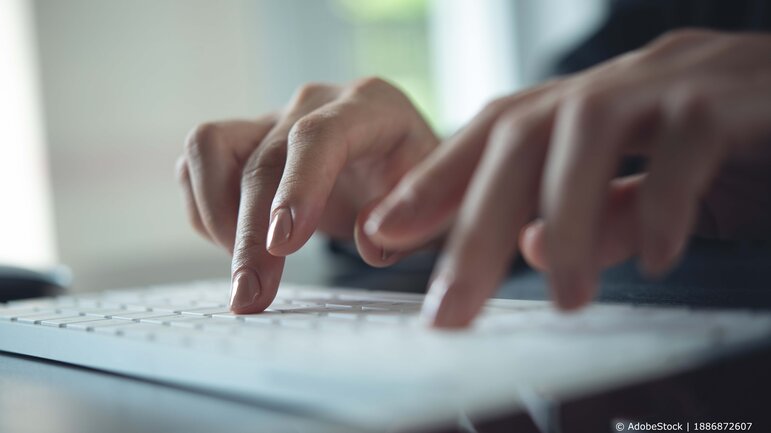 Nahaufnahme von Händen auf einer Laptop Tastatur mit weichem Hintergrund. Die Szene symbolisiert produktives Arbeiten, Homeoffice und digitale Technologien.