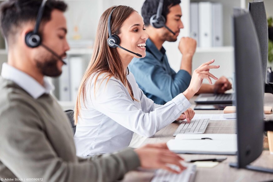 Drei Personen, die im Call Center mit Headset telefonieren.