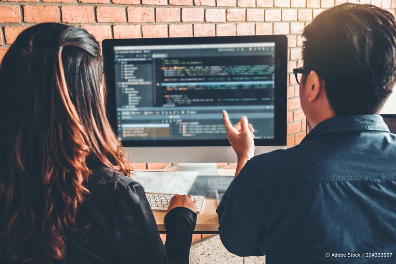 Zwei Entwickler analysieren gemeinsam Code am Bildschirm – Teamarbeit, Softwareentwicklung und kollaboratives Arbeiten in der IT.