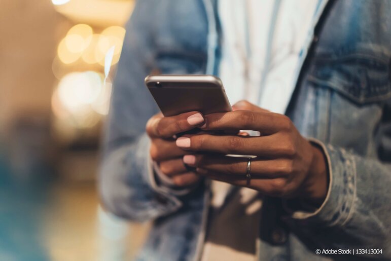 Eine Person nutzt ihr Smartphone, um unterwegs schnell und unkompliziert online zu kommunizieren.