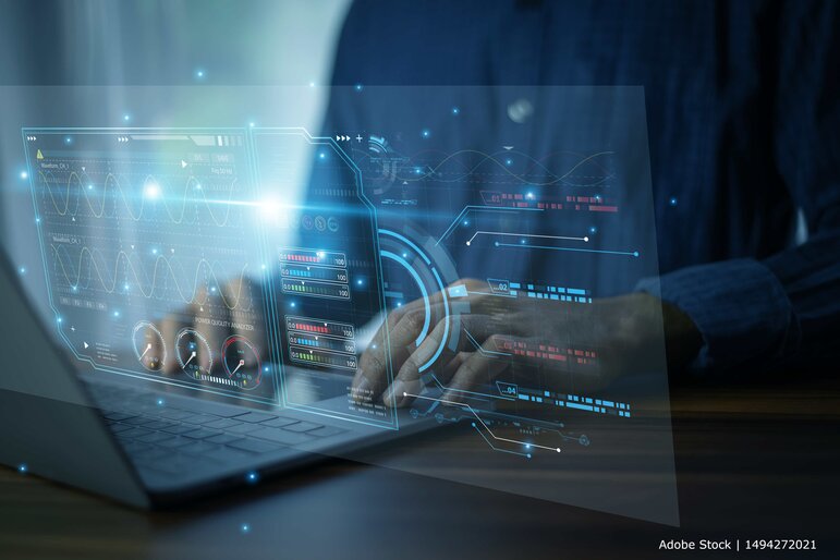 Eine Person arbeitet an einem Laptop mit einer digitalen Benutzeroberfläche zur Analyse und Visualisierung technischer Daten.
