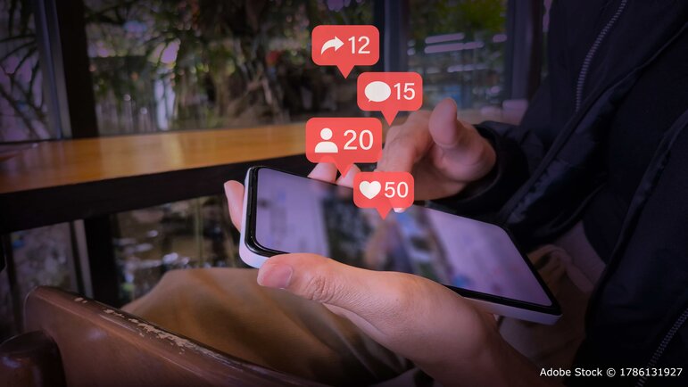 Smartphone mit schwebenden Social Media Kennzahlen