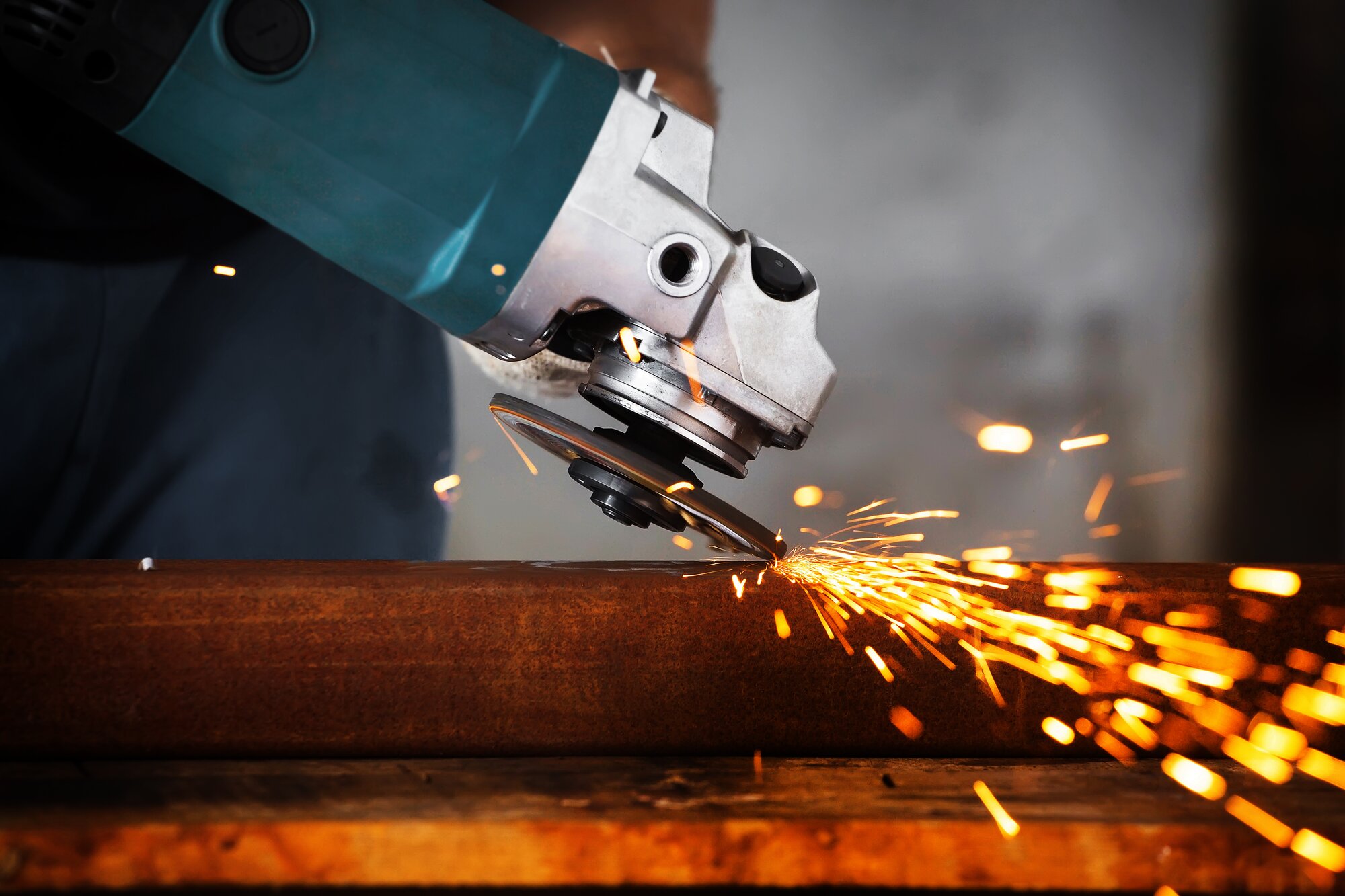 worker using circular saw to cut metal