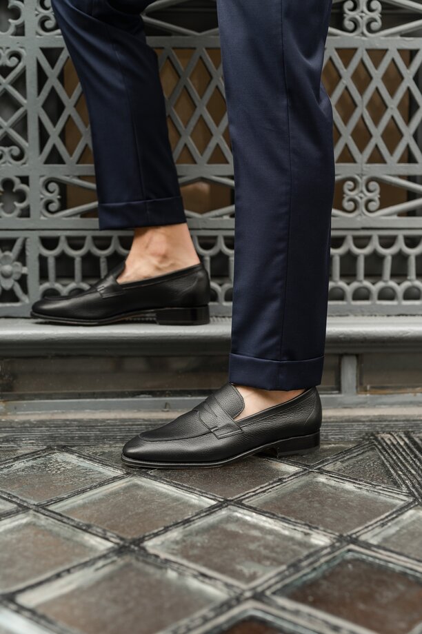 Person standing on steps wearing black unlined loafers
