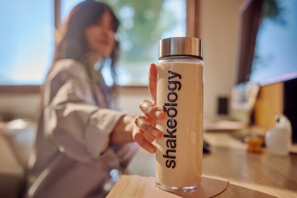 woman reaching for Shakeology