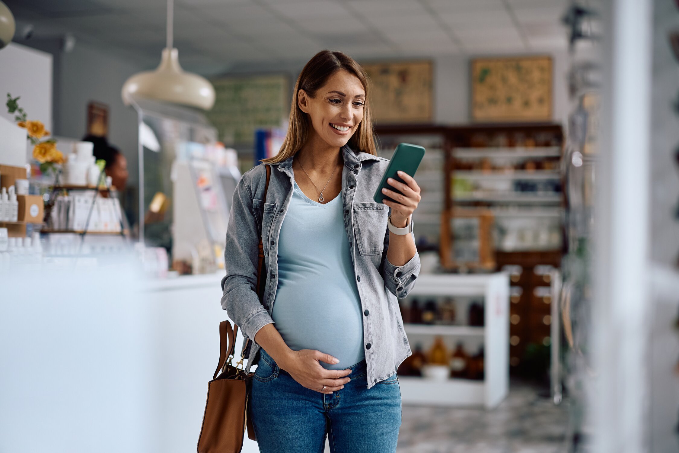 pregnant woman smiling looking at phone