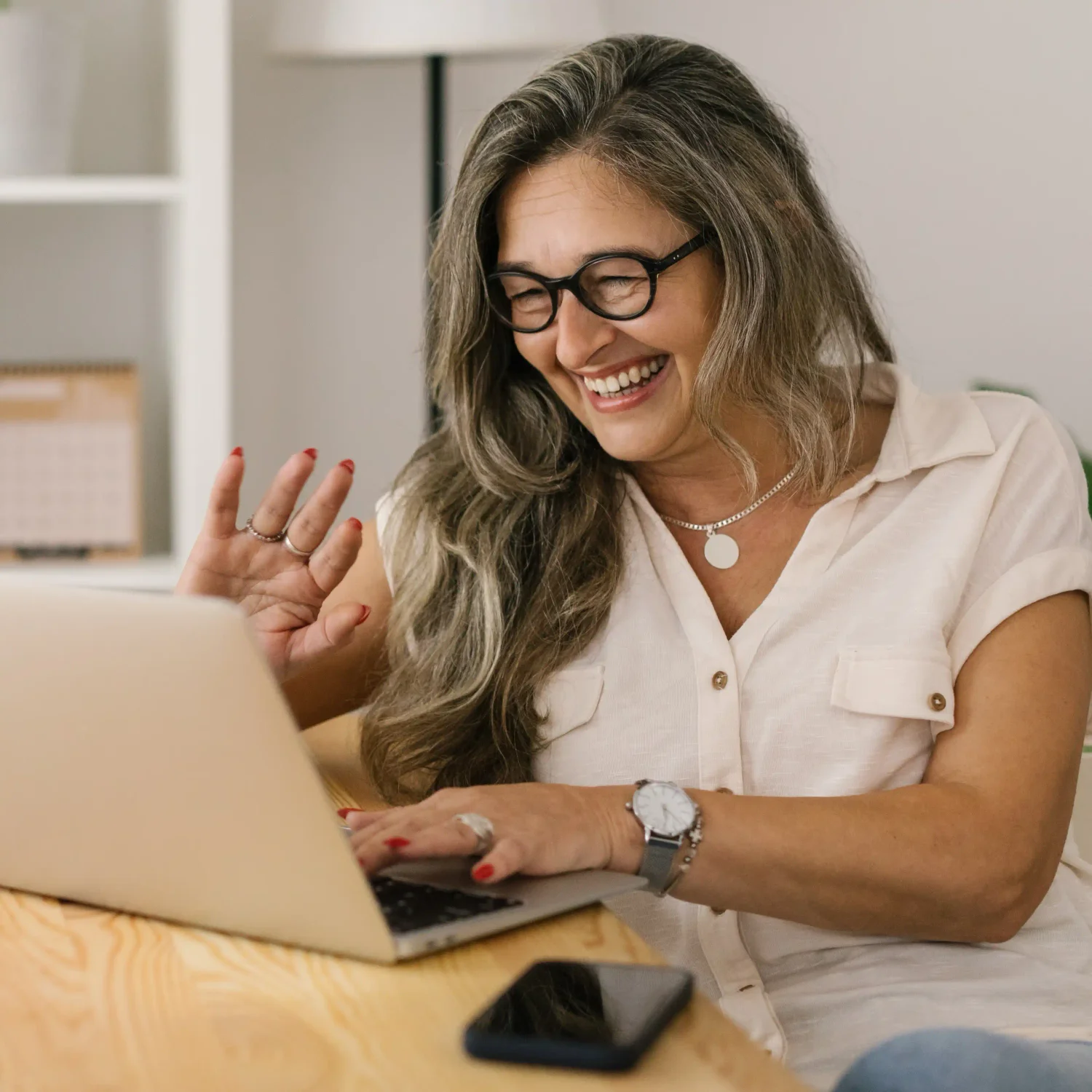 Woman in front of computer waving