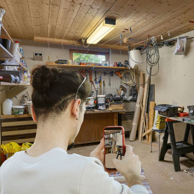 Man scanning a garage workshop with Scansurance to create a visual inventory of tools and belongings for insurance or loss prevention.