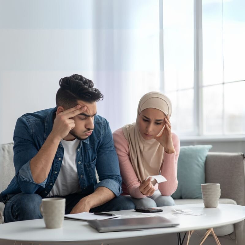 Stressed couple reviewing issues with their new home, seeking a way to document and track belongings and potential maintenance problems.