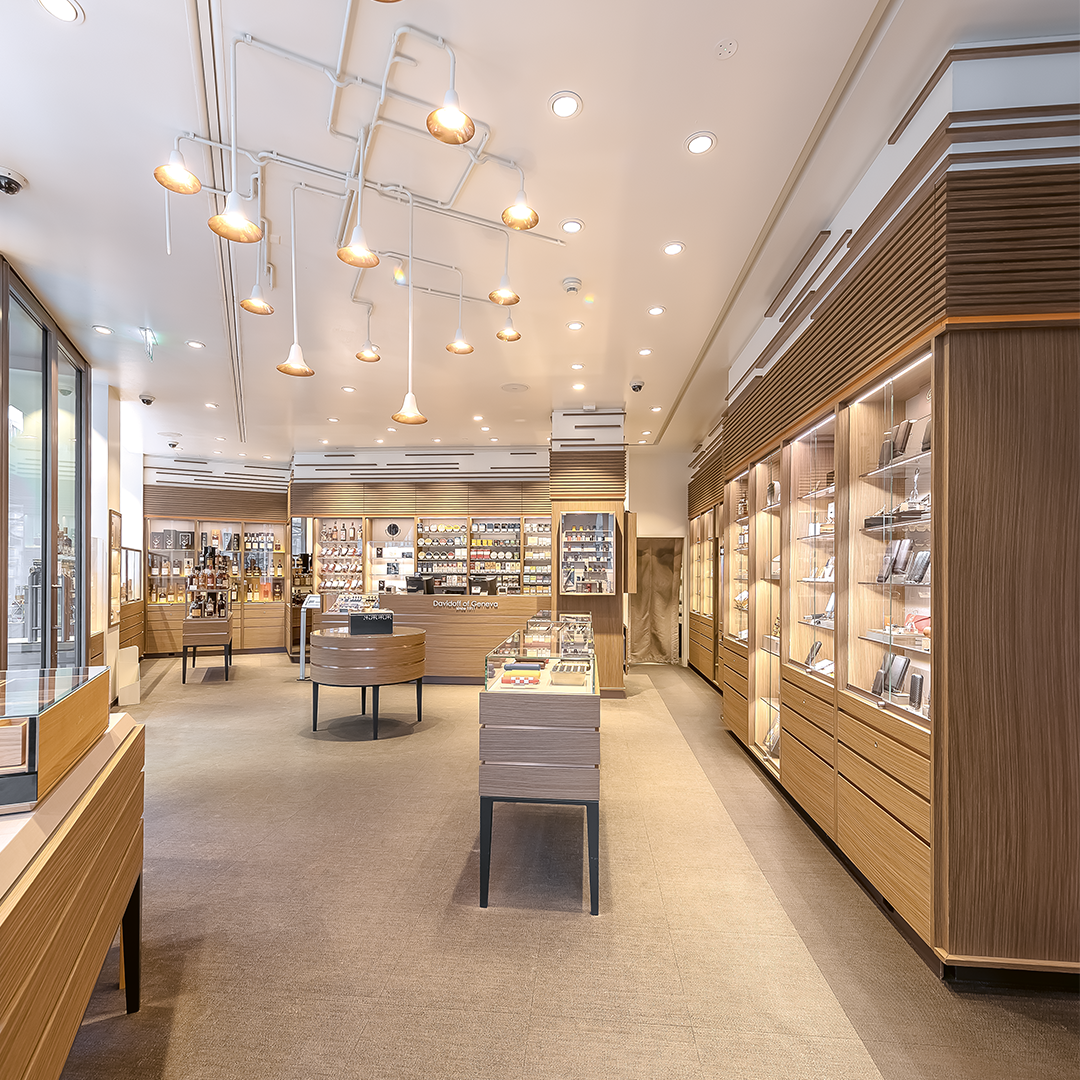 Davidoff Flagship Store in Geneva: A tobacco shop featuring numerous shelves and bright lighting, creating a warm and inviting shopping atmosphere.