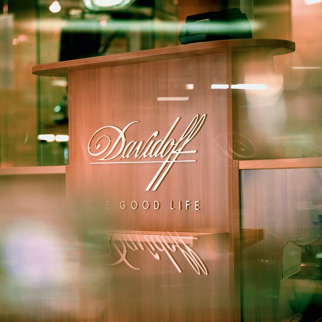 Davidoff Flagship Store in Geneva: A tobacco shop featuring numerous shelves and bright lighting, creating a warm and inviting shopping atmosphere.