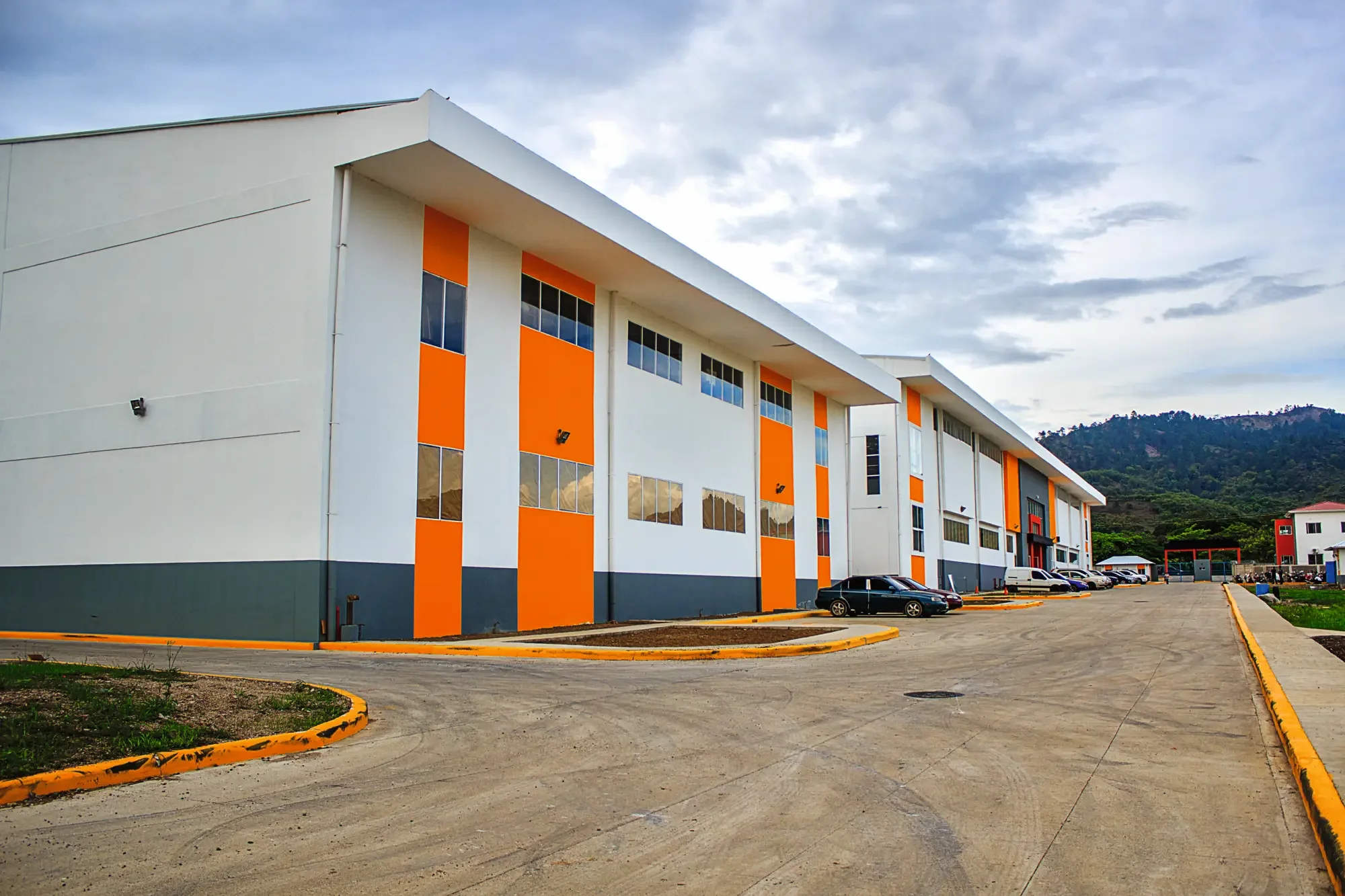 Exterior of the Davidoff manufacturing site in the Dominican Republi. A modern white building with palm trees and landscaped garden, featuring the Davidoff logo above the entrance.