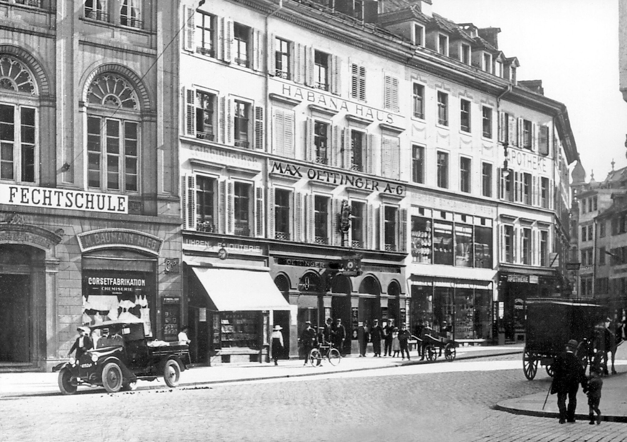 Historical photo of a street with cars and passers-by from times gone by. The first Oettinger davidoff store in Basel, Switzerland in 1911. The shop is located at Eisengasse 9, in Basel, and symbolises Max Oettinger PLC. ( public limited company)