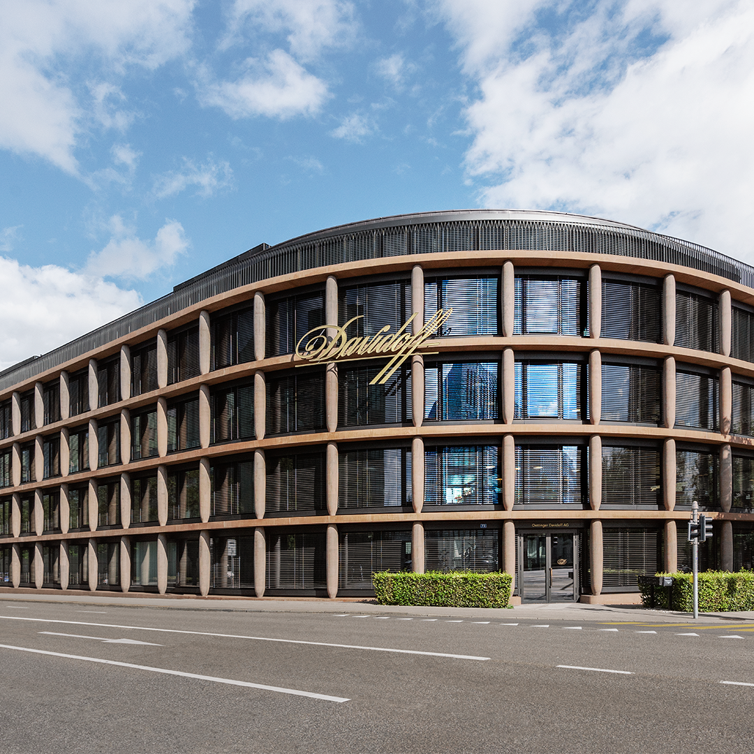  An Oettinger Davidoff, Maison Davidoff building with large glass windows on the façade that reflect the surroundings.