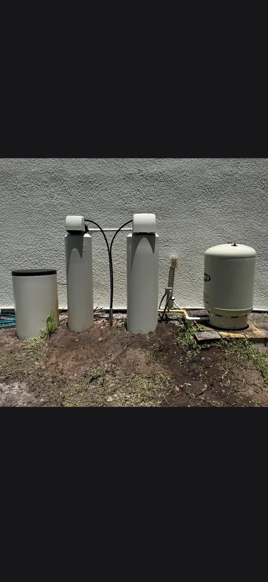 Dual whole-home water treatment system installed beside a Central Florida home