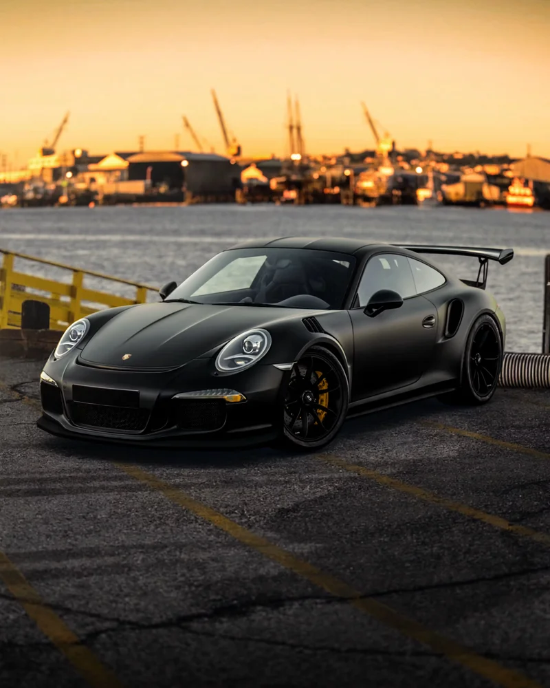 Black sports car parked by the waterfront