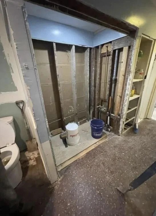 Bathroom before renovation with damaged shower tile and dated fixtures