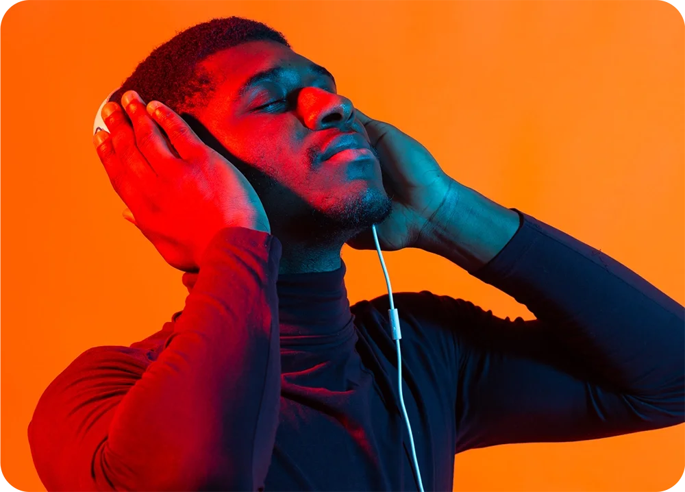 A man putting his hands on his headphones listening to music