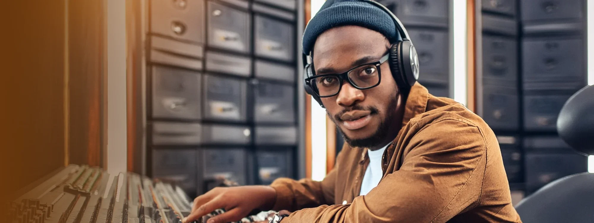 A man wearing headphones sitting in a studio