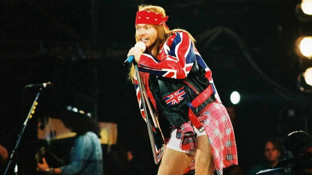 Axl Rose on stage singing into a microphone