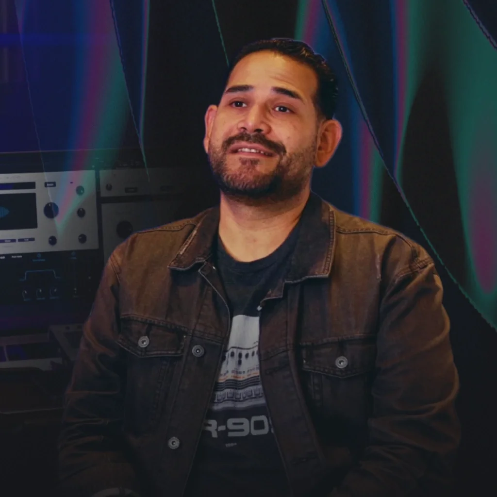 Junior Sanchez sitting in front of a computer monitor running AutoTune