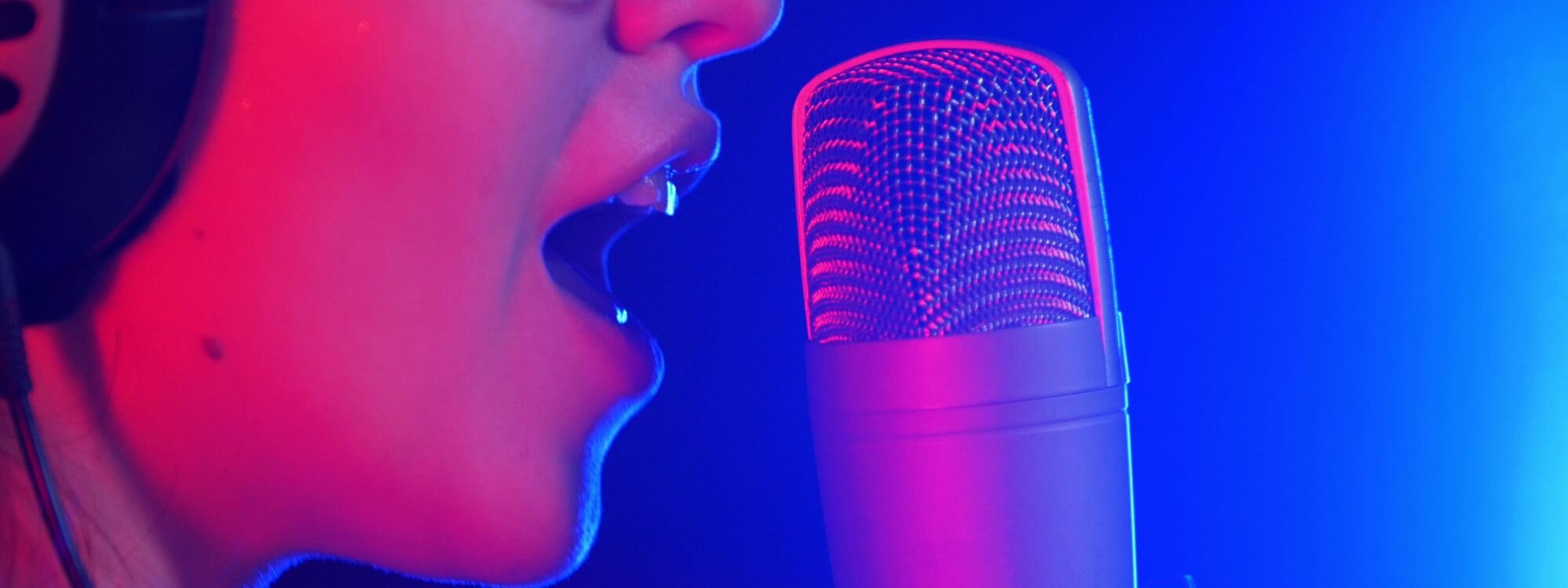 Close up of a females face singing into a microphone