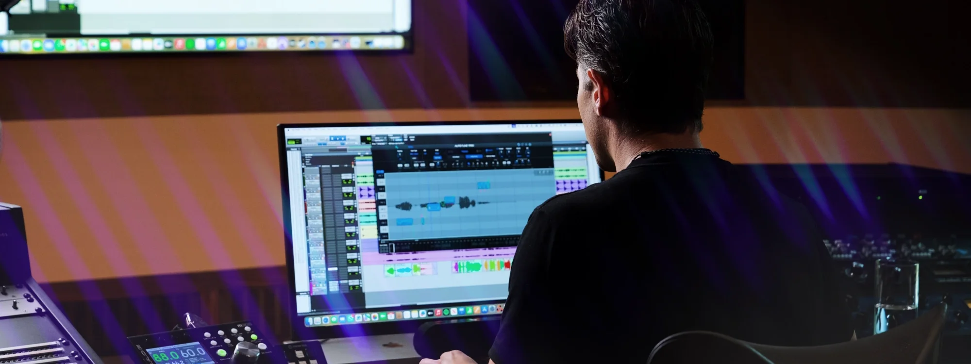 A man sitting in front of a computer running a DAW