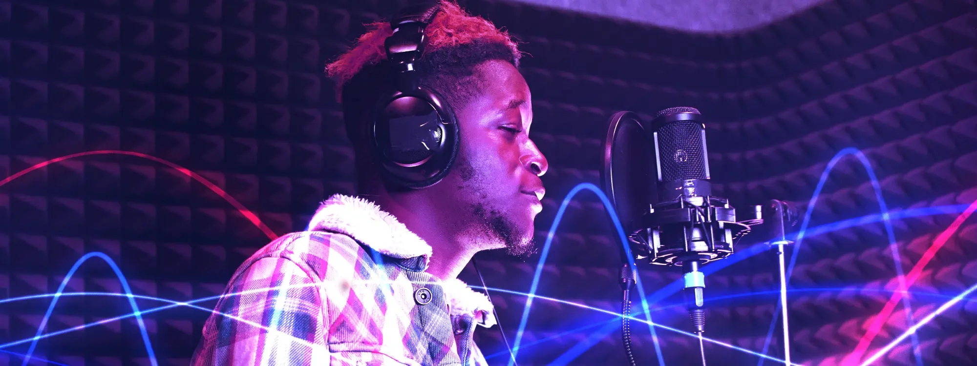 A man wearing headphones singing into a microphone
