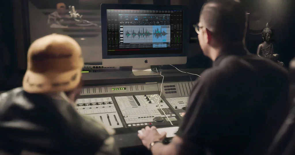 Two men looking at a computer screen running AutoTune