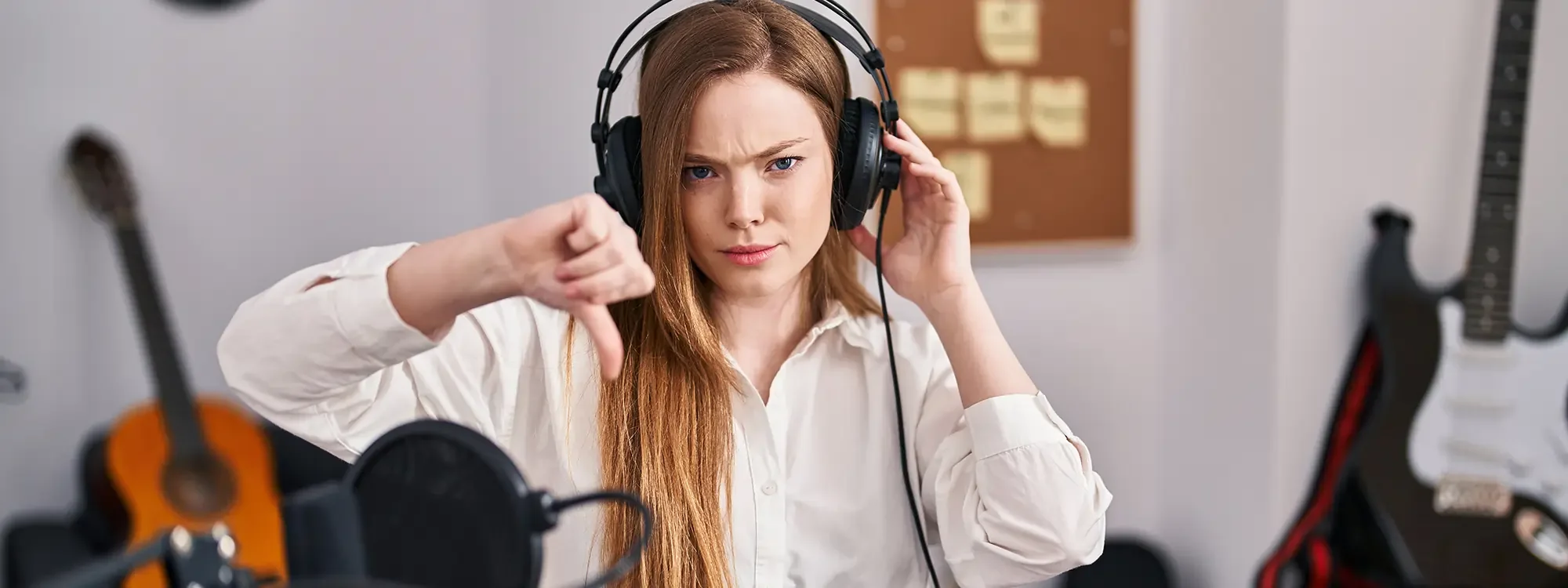 Girl wearing headphones giving a thumbs down