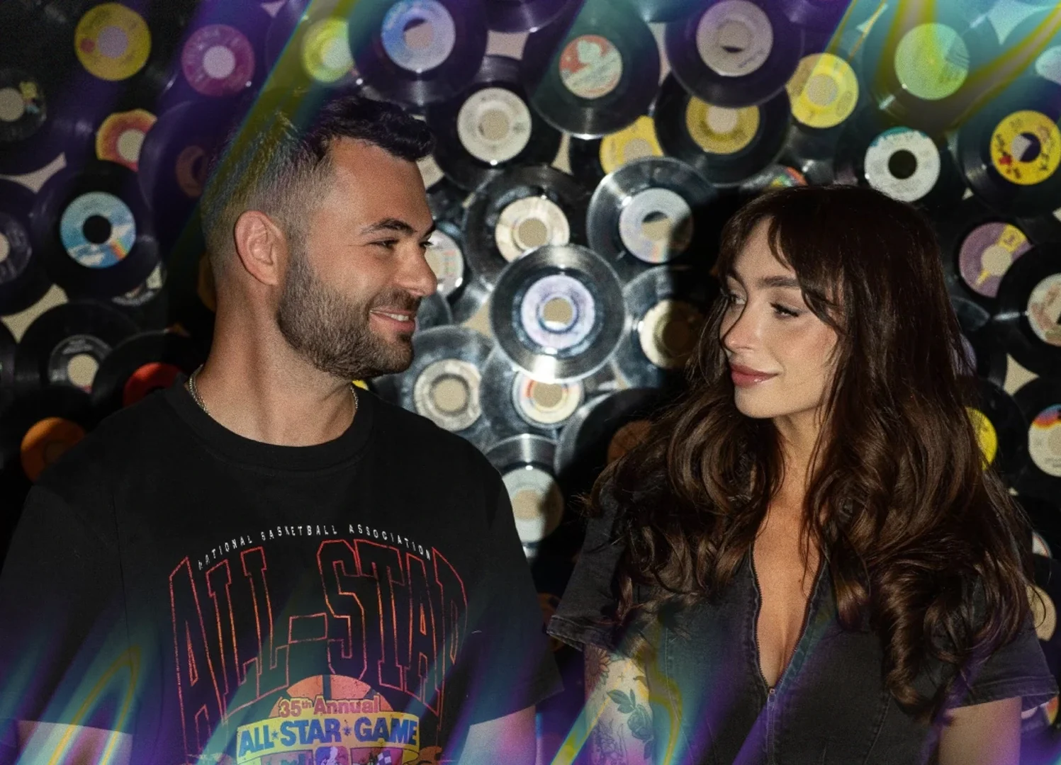 A man and a woman looking at each other in front of a vinyl record wall