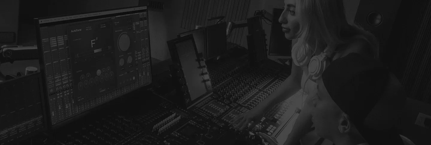 A man and a woman sitting in a recording studio in front of computer screens