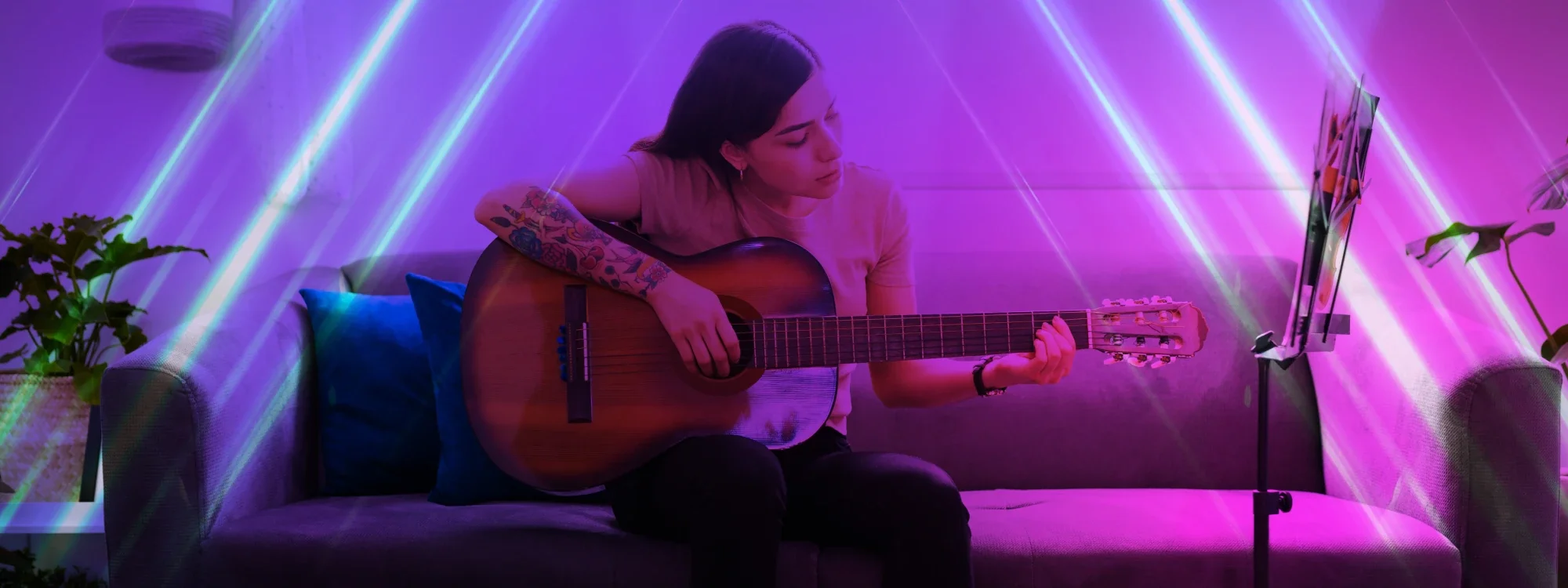A woman sitting and playing the guitar