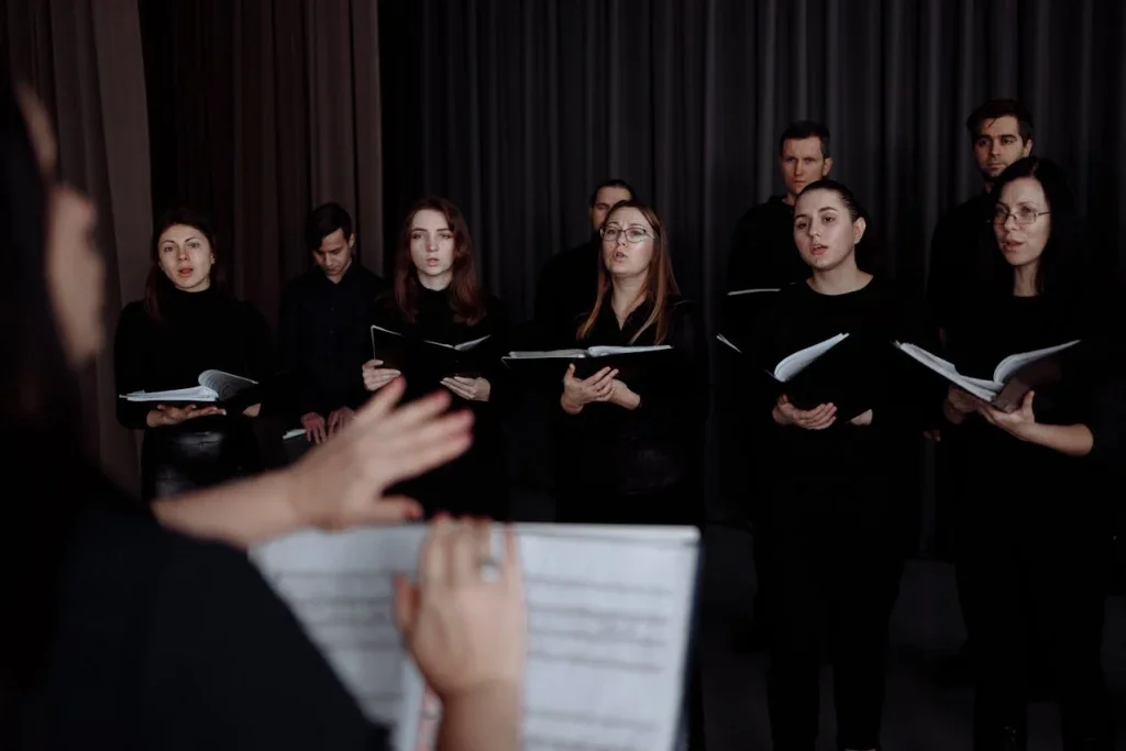 A choir of women singing with direction from a female conductor