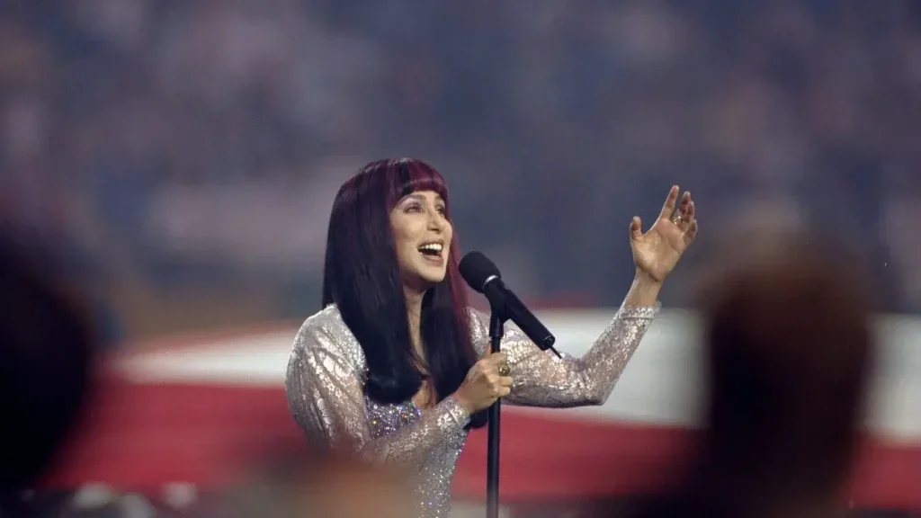Cher singing into a microphone