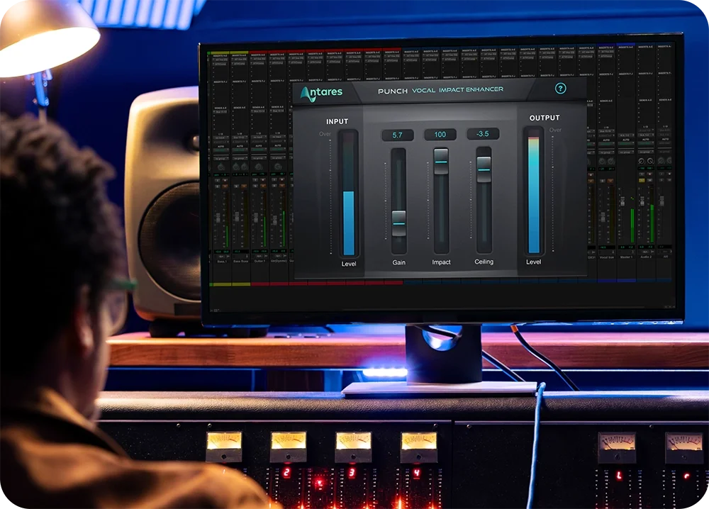 A man in a recording studio using Punch by AutoTune on a computer