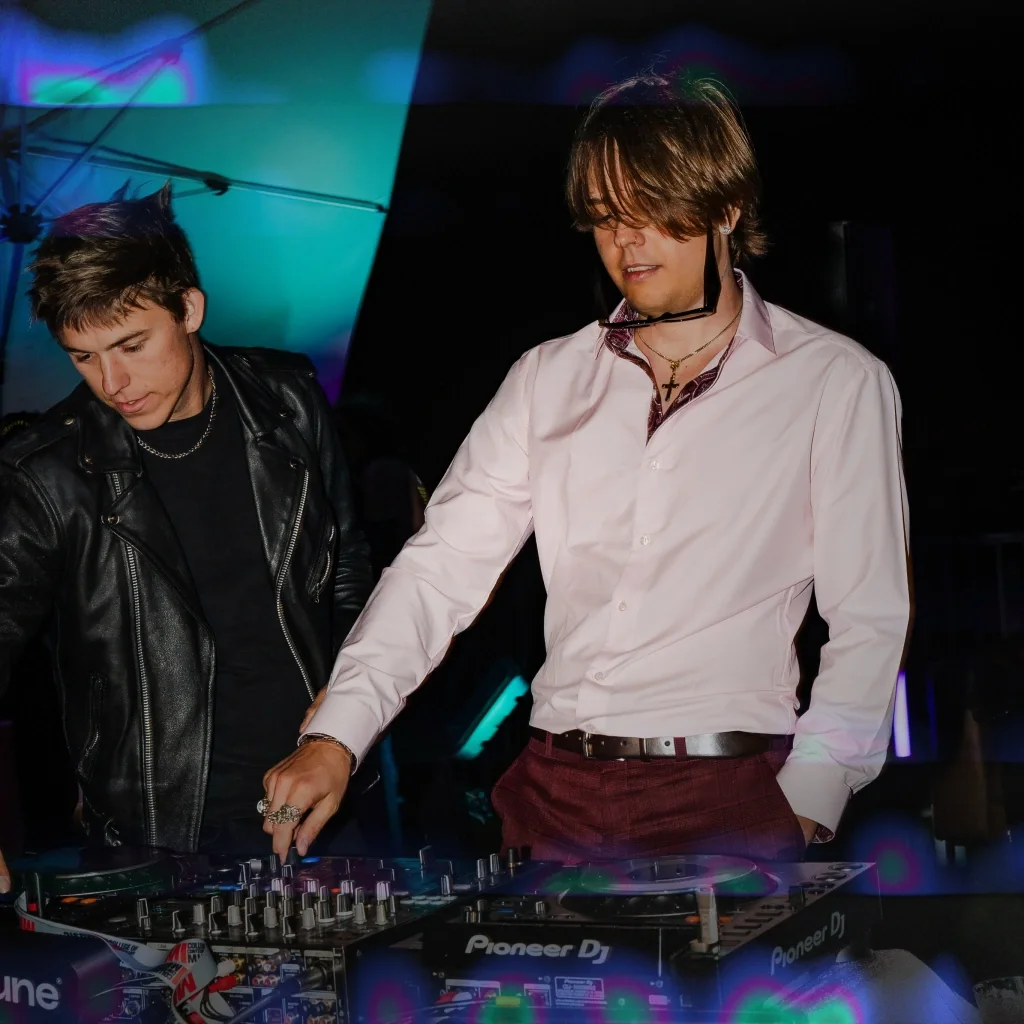 Two men standing next to each other DJing