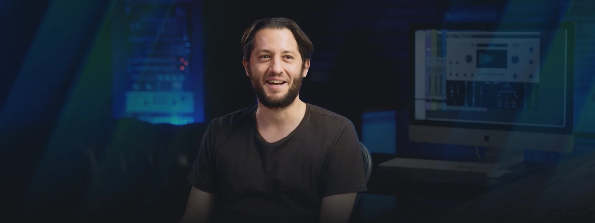 Ian Kirkpatrick sitting in the center with a computer behind him running AutoTune
