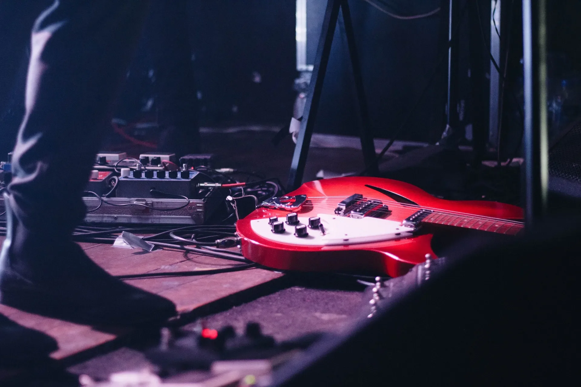 A red guitar laying on the floor of a studio