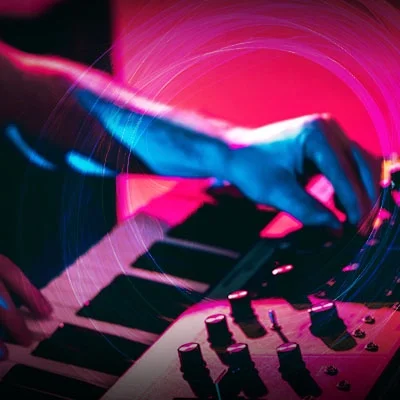 Hands playing the keys and adjusting levels on a midi