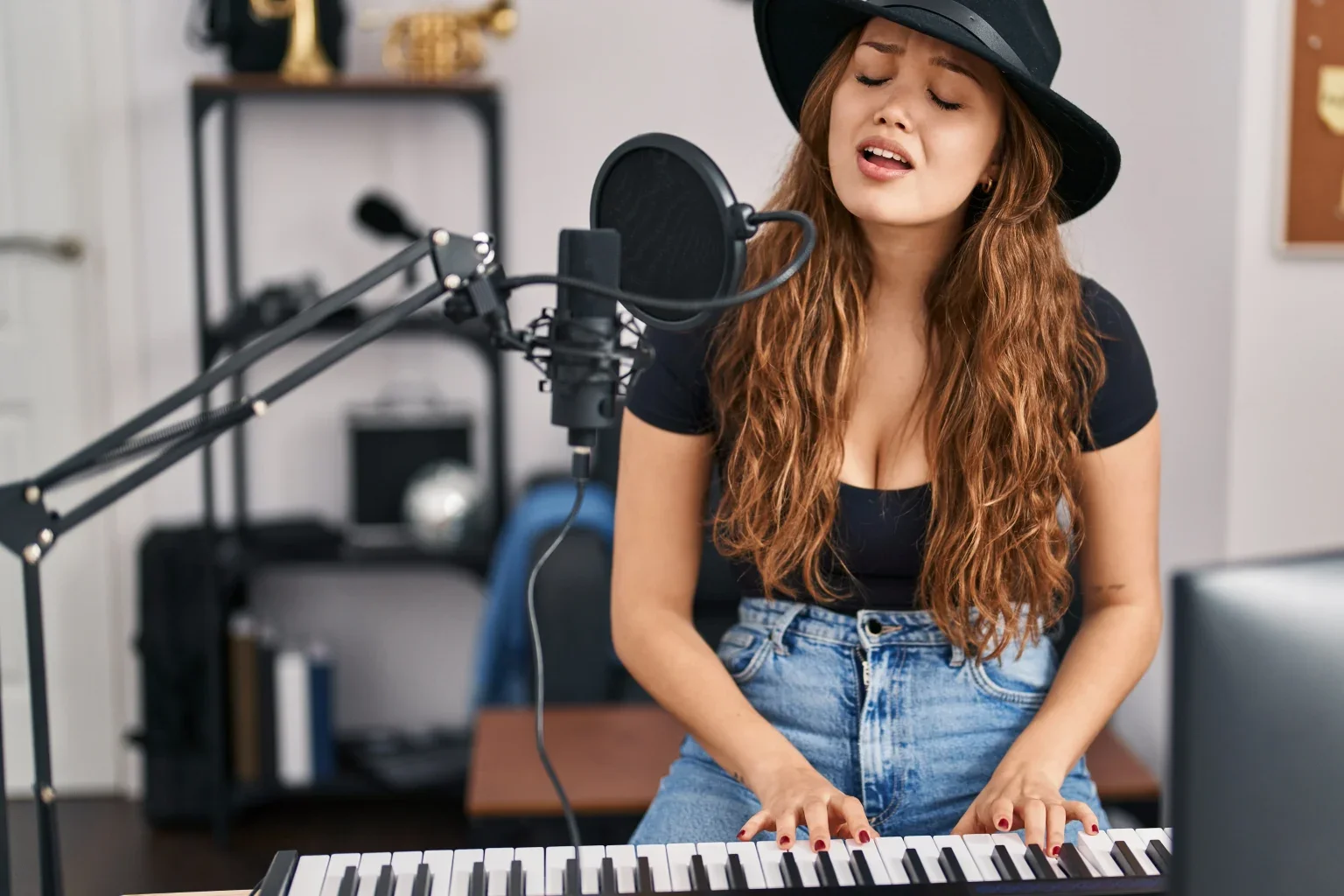 A woman playing a keyboard and singing into a microphone