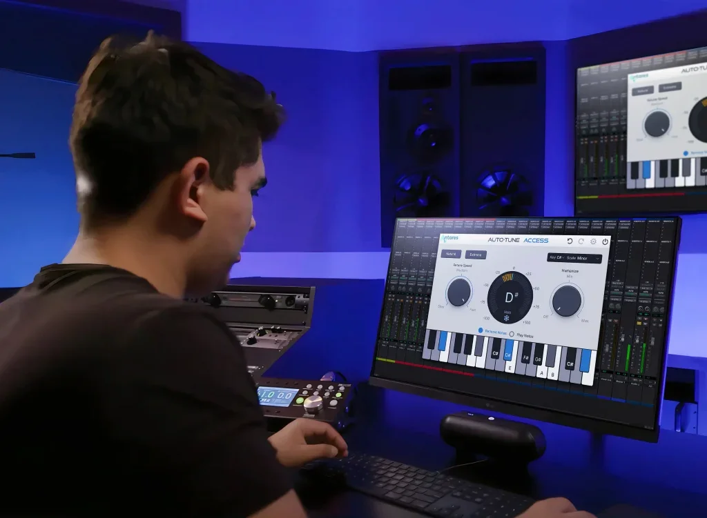 A man sitting in front of a computer with AutoTune Access 10 the screen