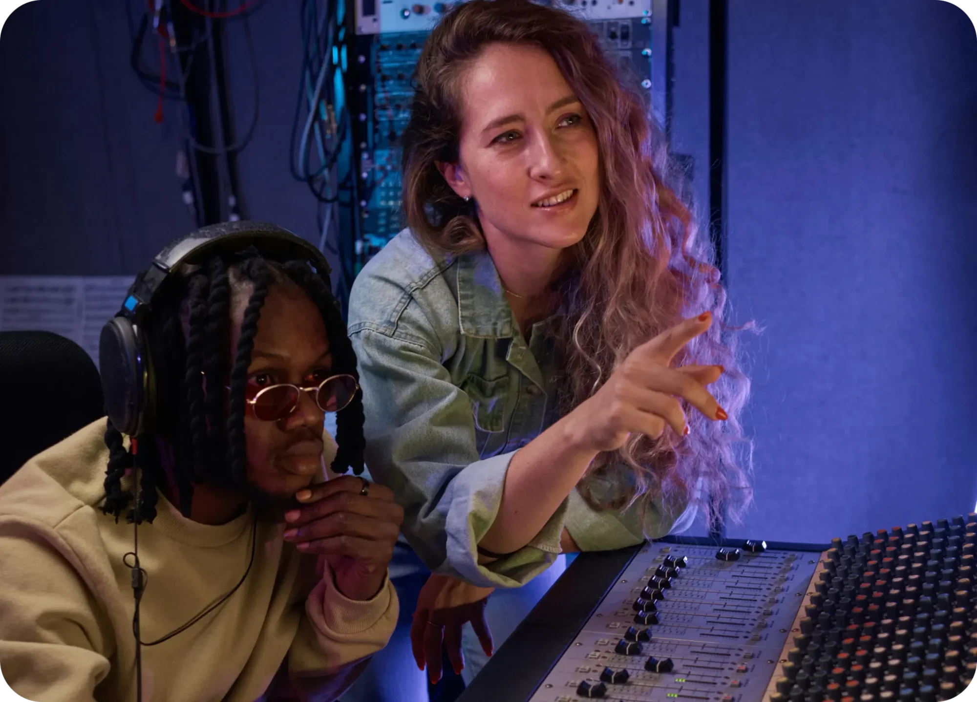 a male and female in the recording engineer room working at the mixing board console